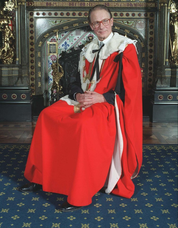 a man in a red robe is sitting in front of a fireplace