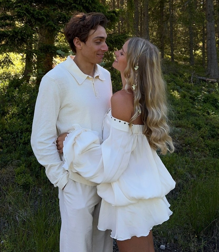 a man and a woman are posing for a picture in the woods