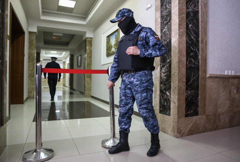 a man in a military uniform is standing in a hallway