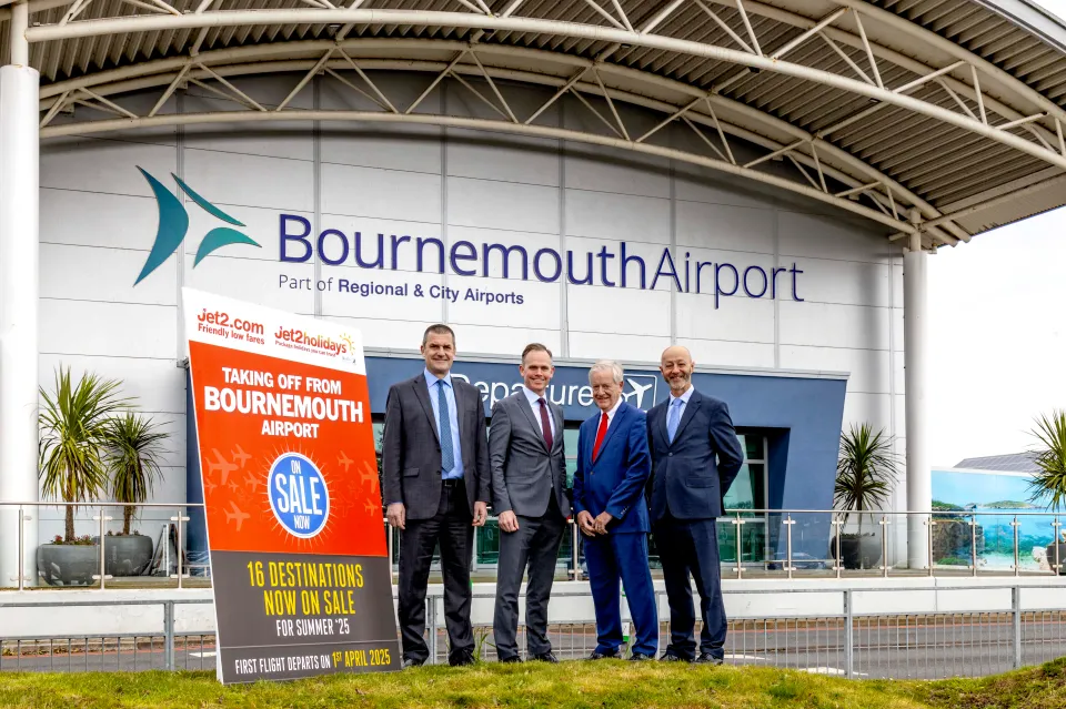 a group of men standing in front of bournemouth airport