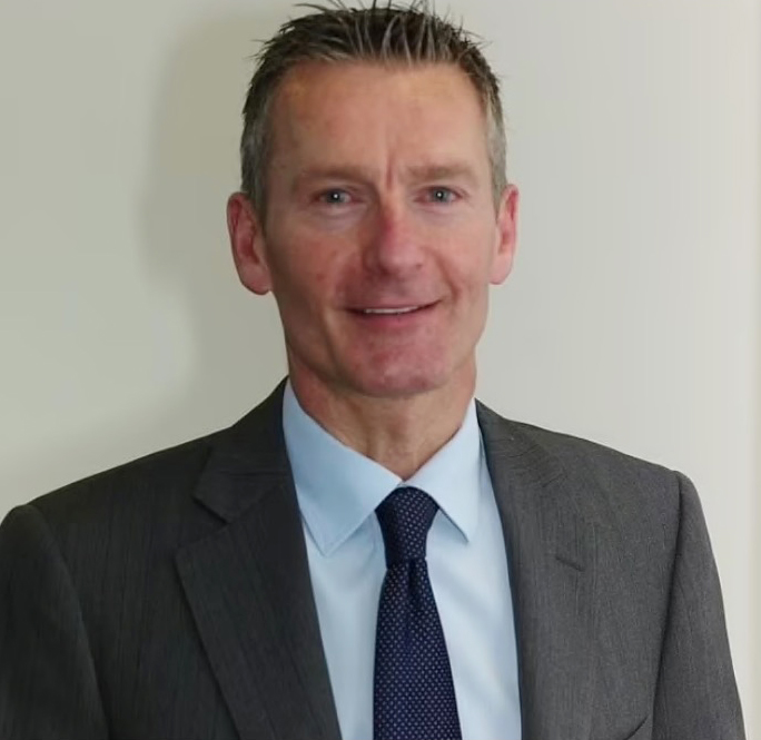 a man in a suit and tie smiles for the camera
