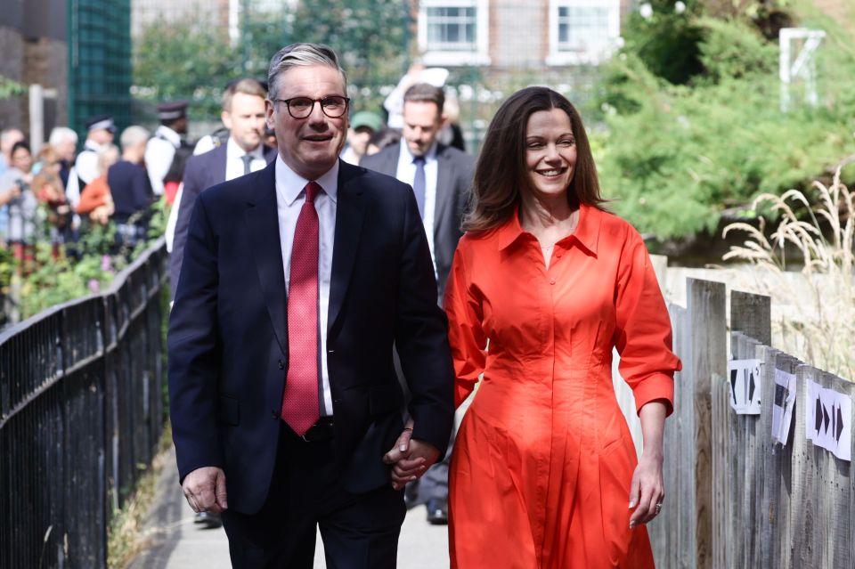a man in a suit and tie holds hands with a woman in an orange dress