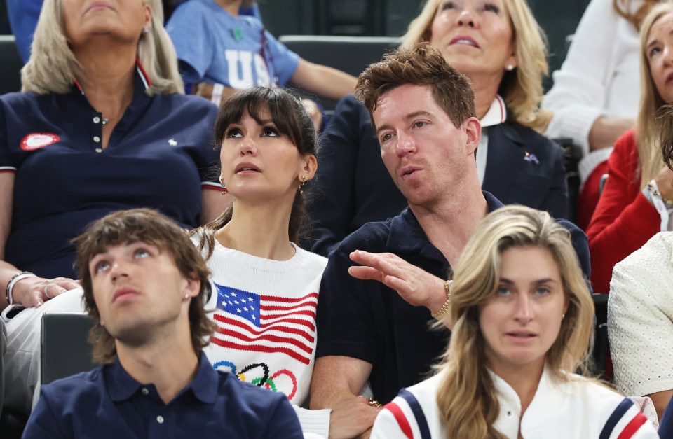 a group of people sitting in a stadium with one wearing a shirt that says u.s.