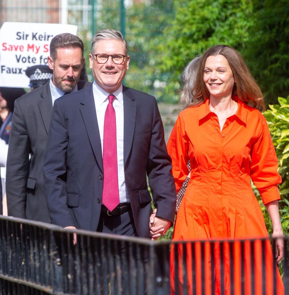 a man in a suit and tie holds hands with a woman in an orange dress