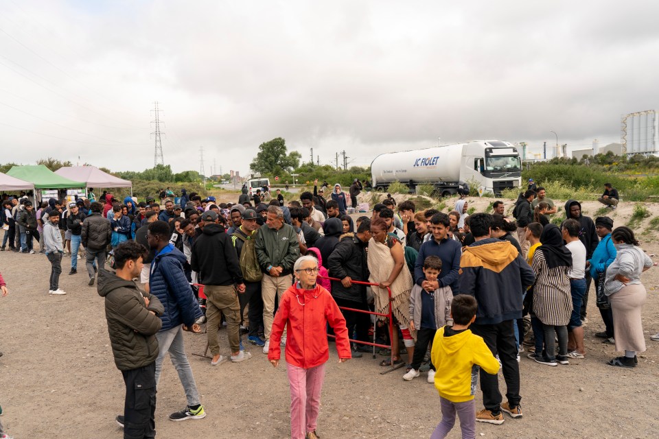 Migrants queuing at a food bank in Loon-Plage