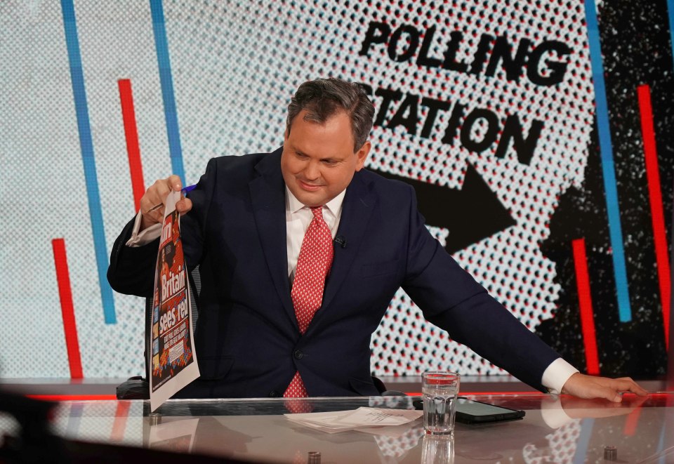 a man sitting at a table with a sign that says polling station