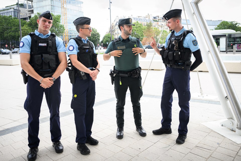French cops are working alongside more than 30 other nationalities in the mammoth security op - pictured a Spanish Guardia Civil talking to French Gendarmes