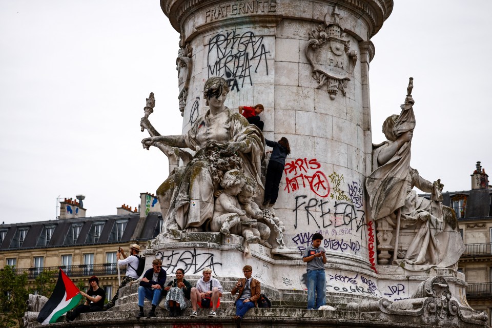 a statue with graffiti on it including the word paris