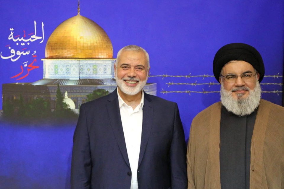 two men standing in front of a poster with arabic writing