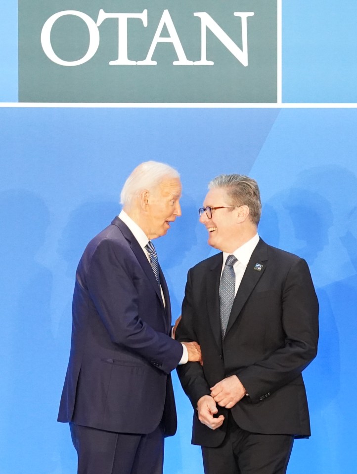 two men shaking hands in front of a sign that says otan