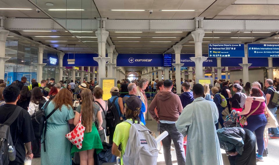 a large group of people are waiting in a line under a eurostar sign