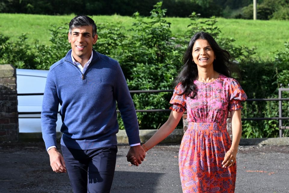 a man in a blue sweater and a woman in an orange dress are holding hands