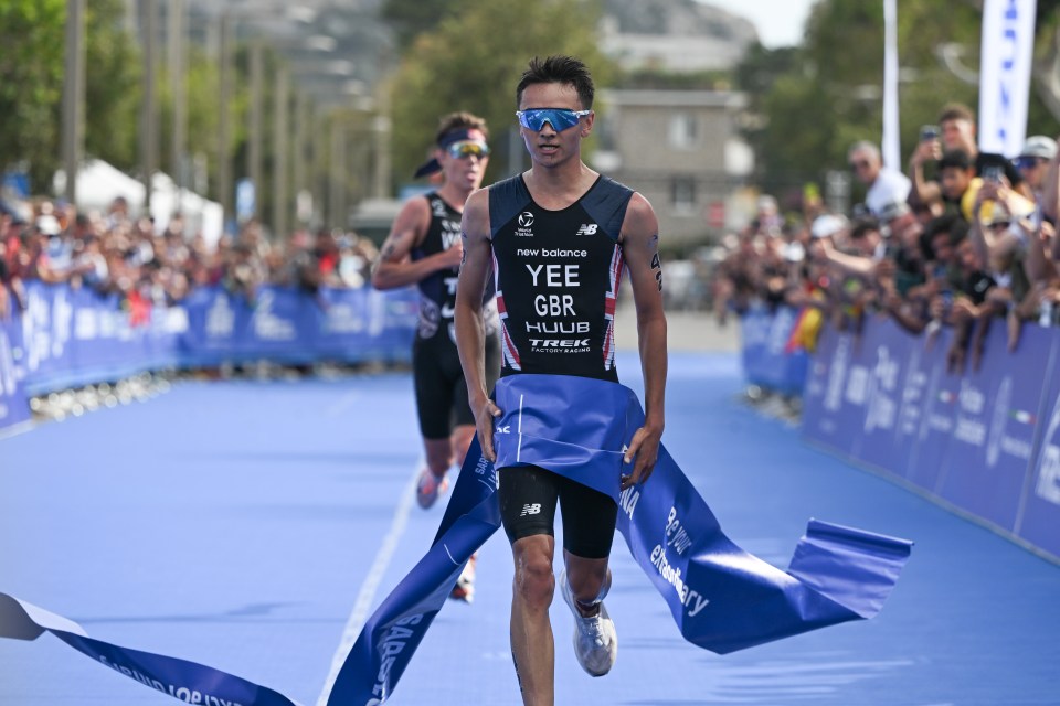 a runner wearing a new balance shirt crosses the finish line