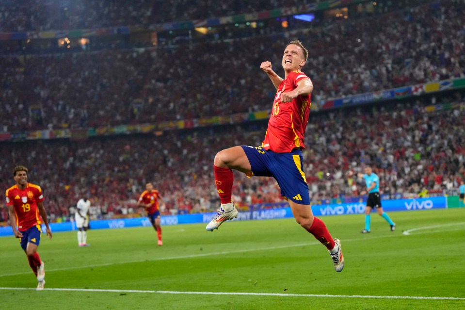 a soccer player in a red and yellow jersey jumps in the air