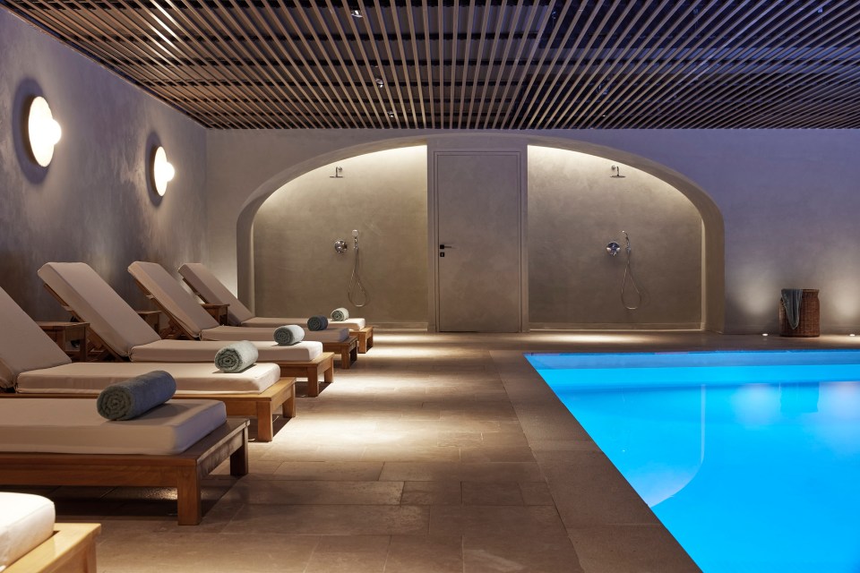 a row of lounge chairs next to a swimming pool