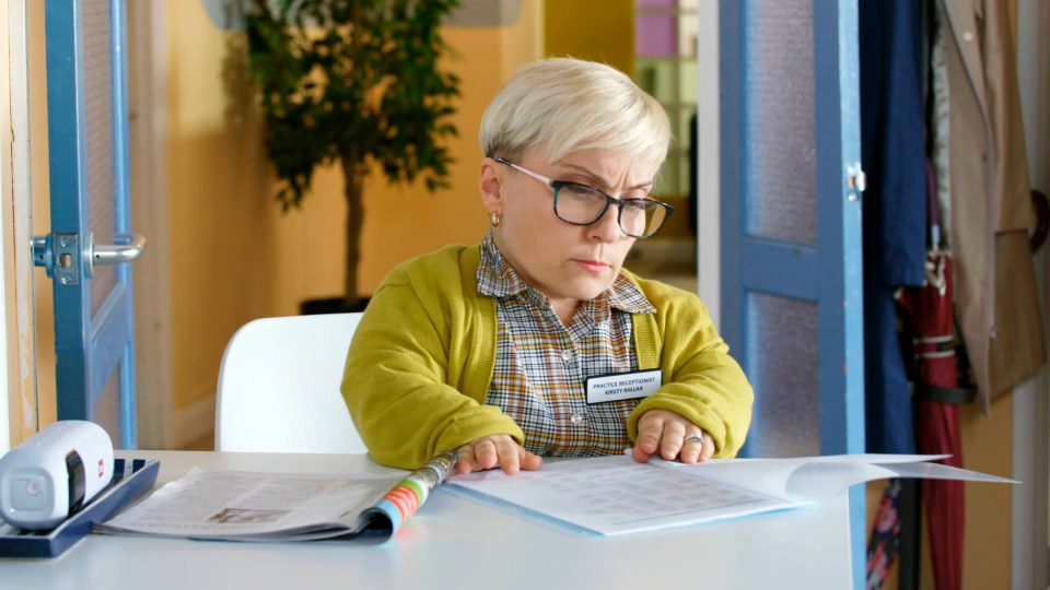 a woman sitting at a desk with a name tag that says ' aleksandra ' on it