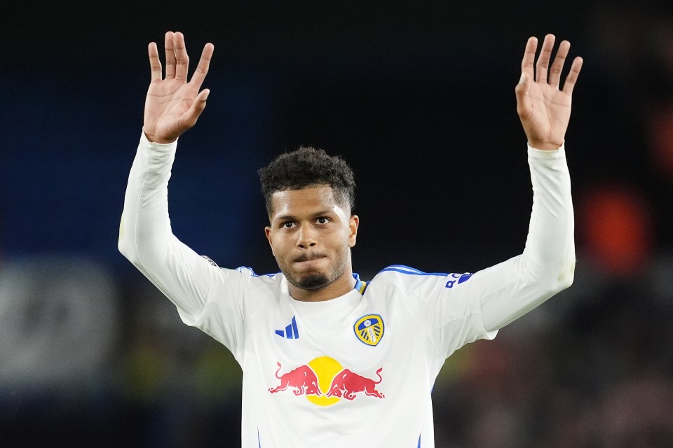 a soccer player wearing a white jersey with a red bull on it