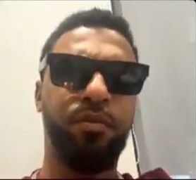 a man with a beard and sunglasses is making a funny face .