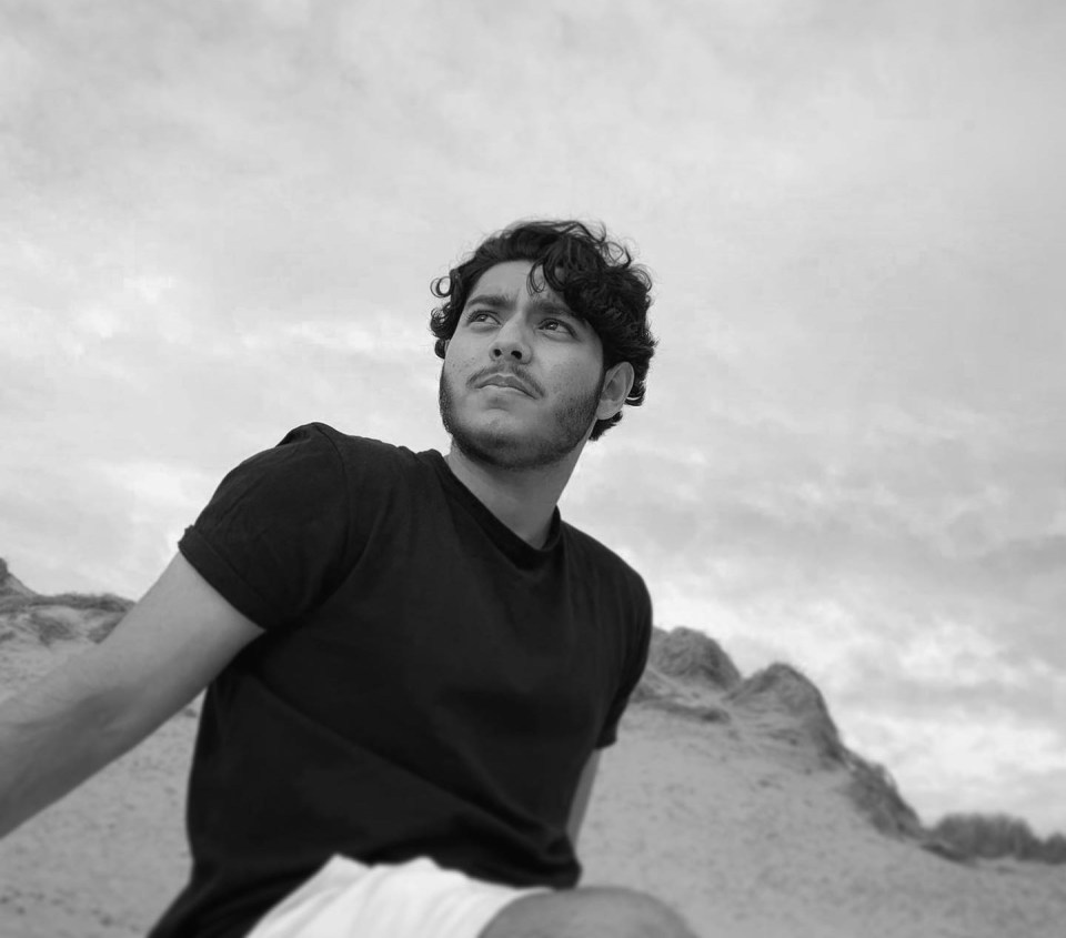 a man in a black shirt looks up at the sky