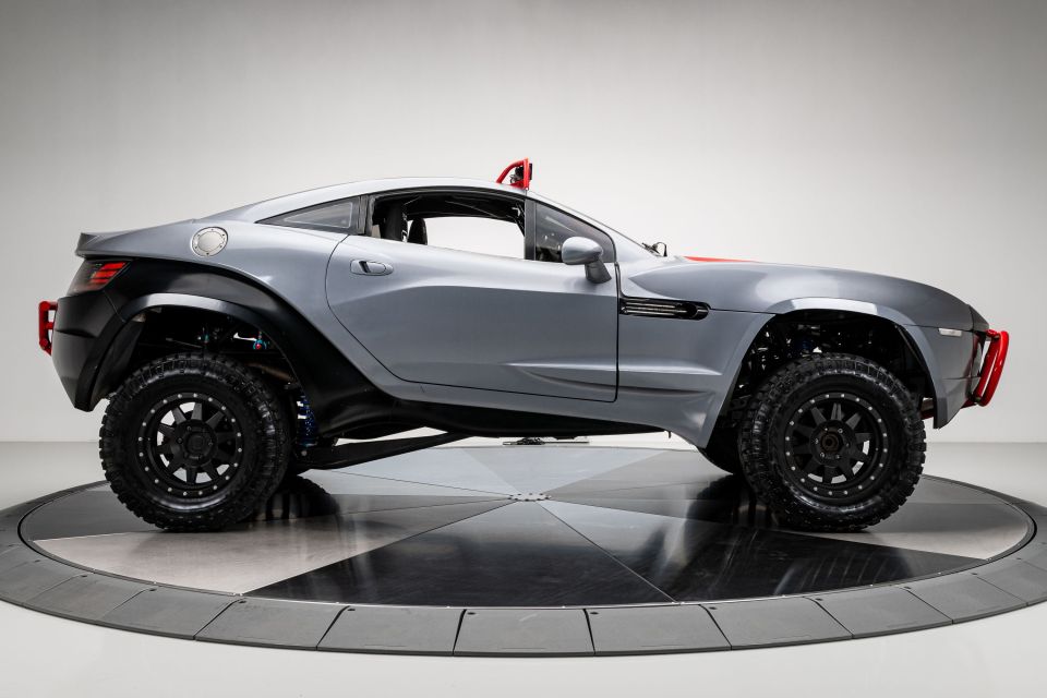 a gray car with black tires is on display
