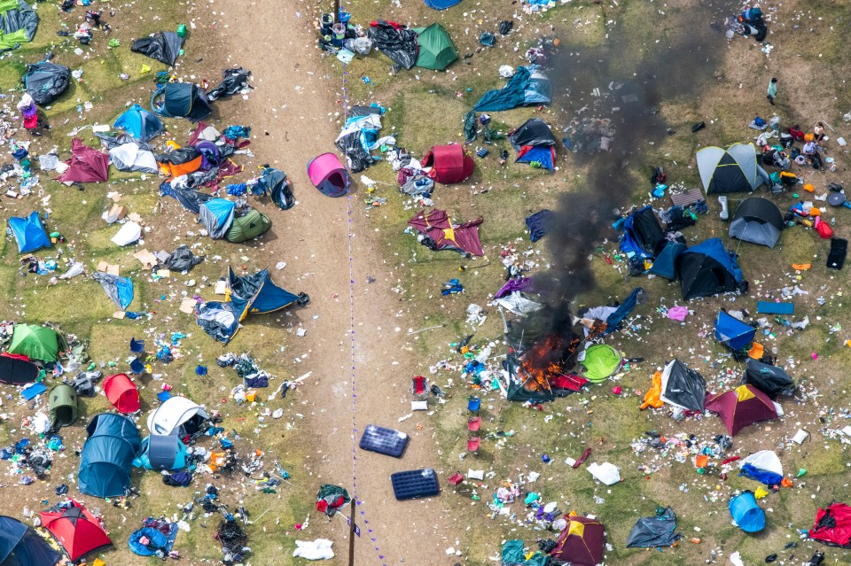 an aerial view of a messy field with tents and trash