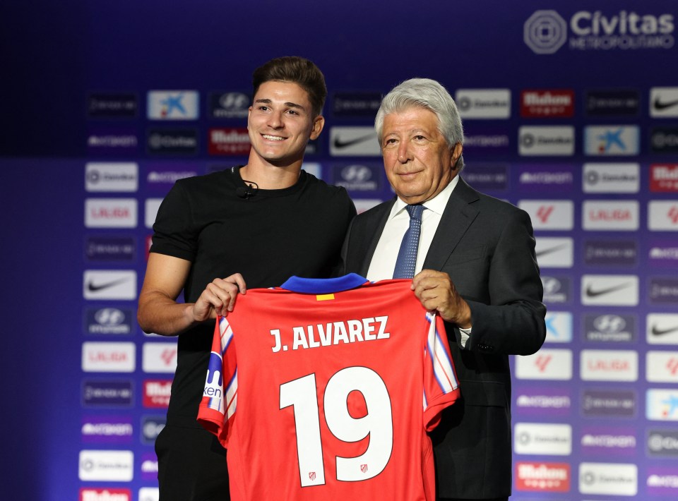 j. alvarez holds up a jersey with the number 19 on it
