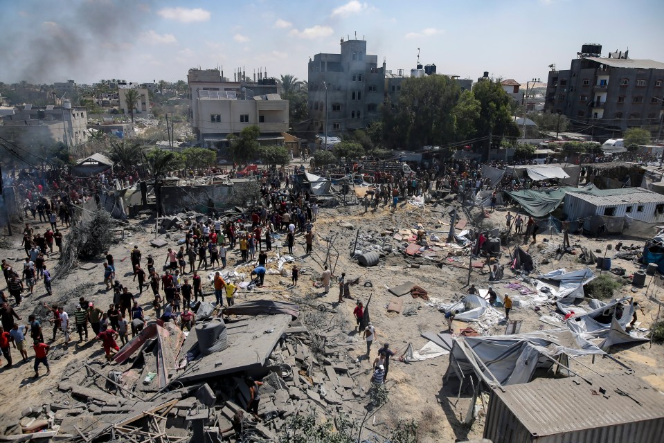a large group of people are gathered around a pile of rubble