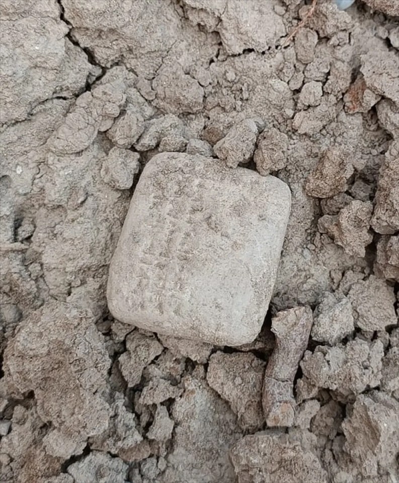 a square piece of concrete is laying in a pile of dirt