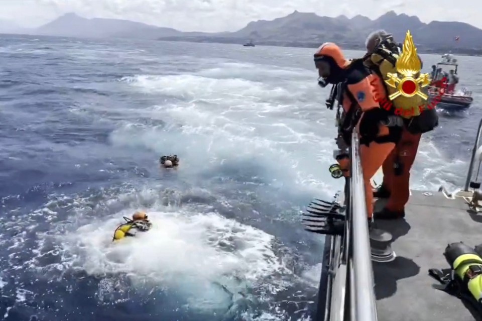 a group of scuba divers are on a boat in the ocean