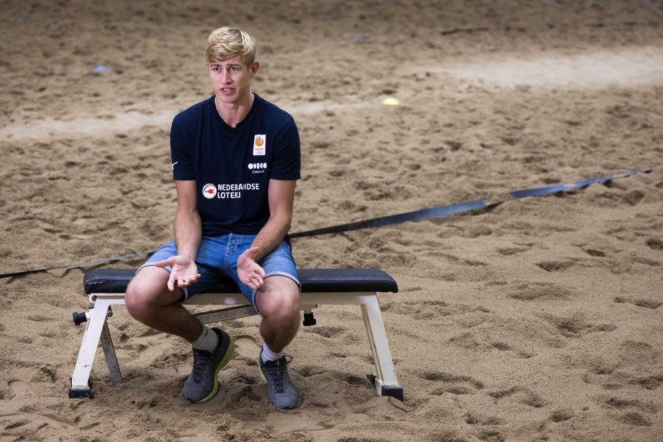 a man sits on a bench wearing a shirt that says netherlandse loterij