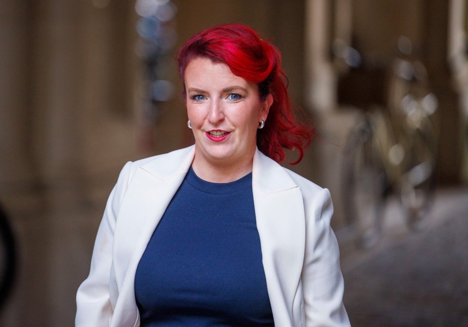 a woman with red hair is wearing a white jacket