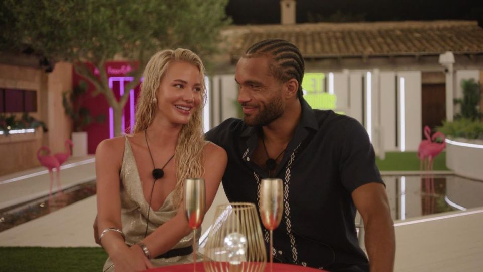 a man and a woman are sitting at a table with champagne glasses