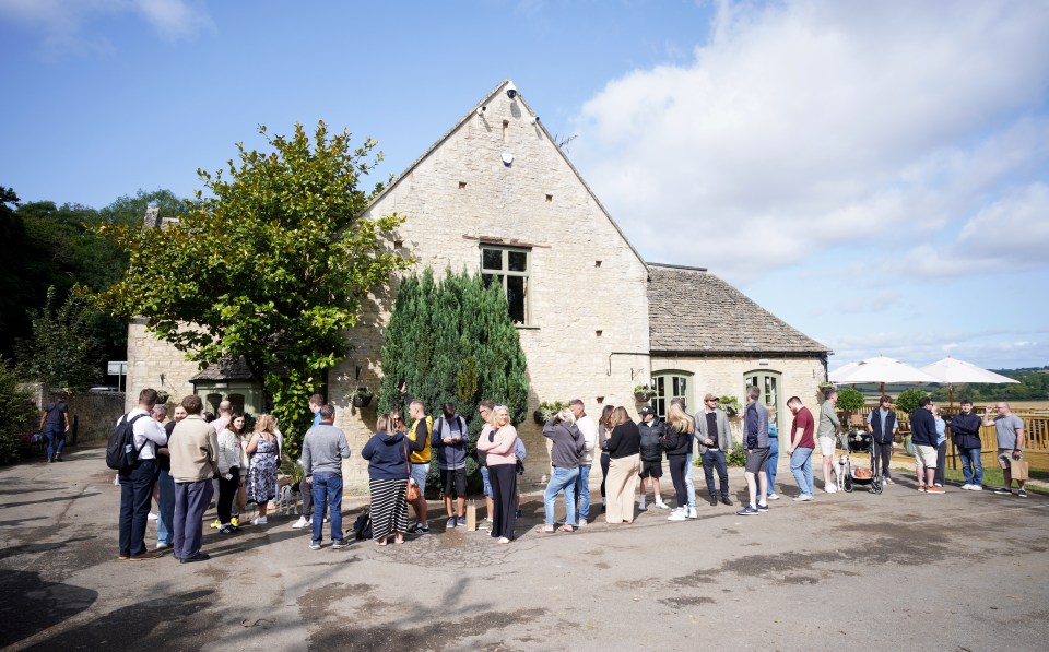 a group of people standing in front of a stone building