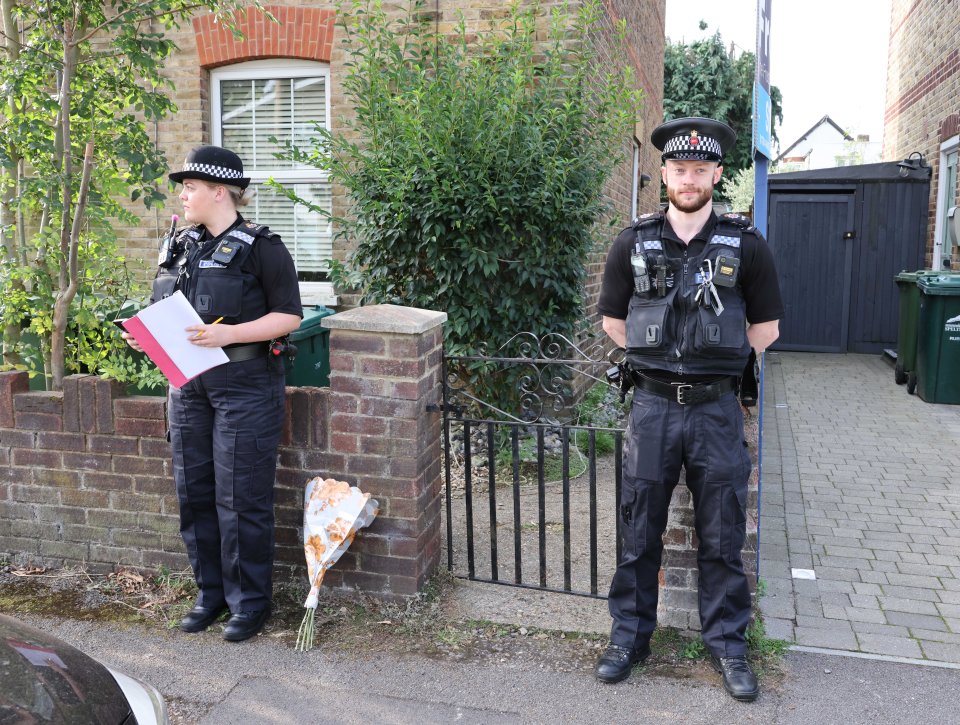 two police officers standing in front of a brick wall