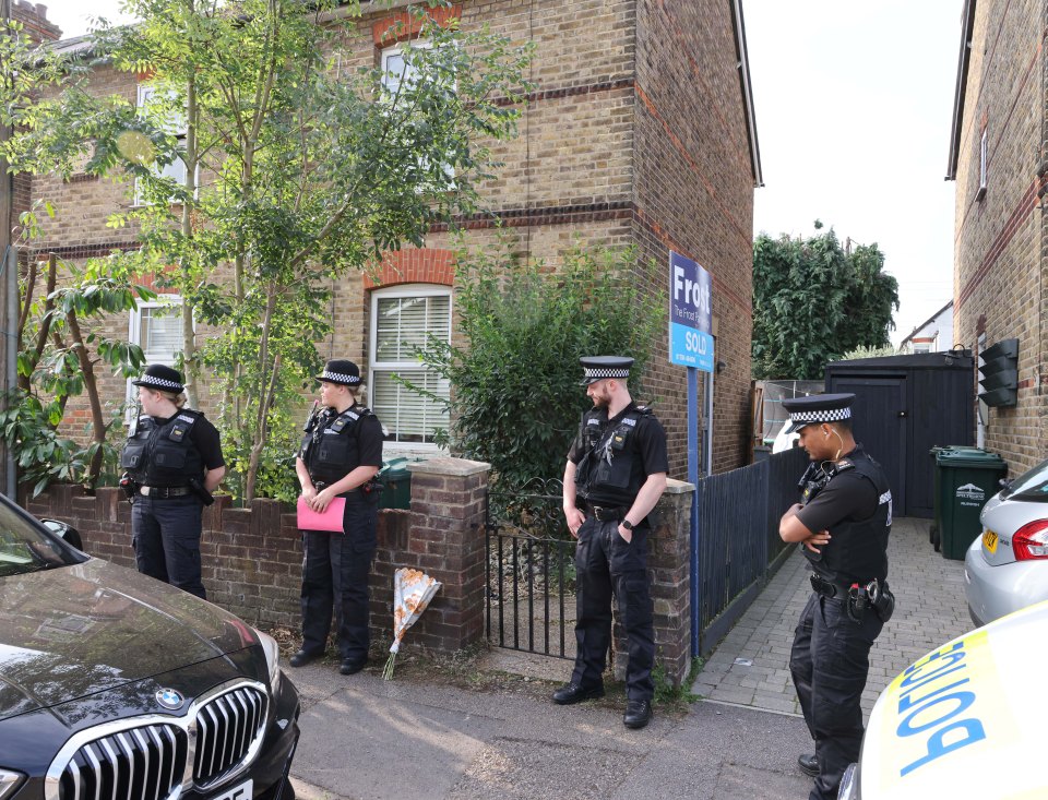 police officers stand in front of a house with a for sale sign