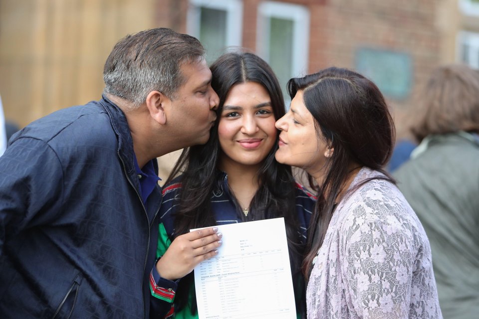 a man kisses a woman on the cheek while holding a piece of paper