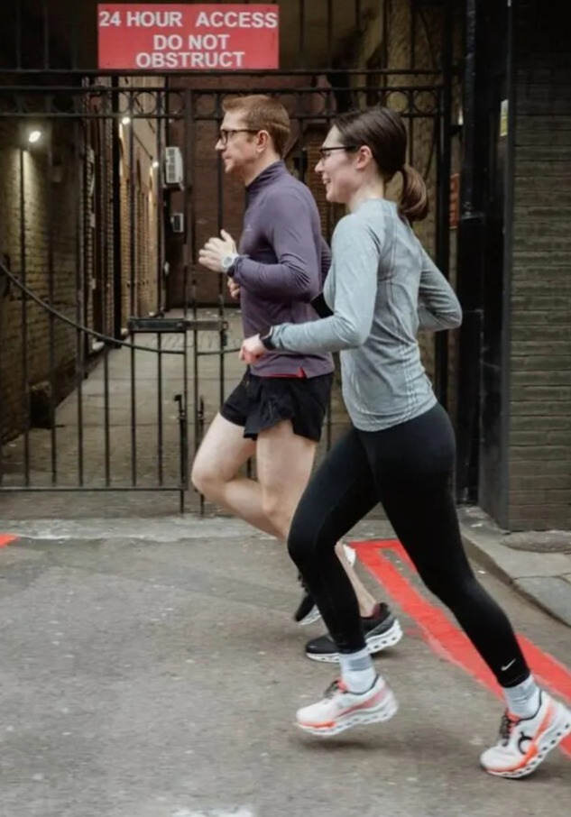 two people are running in front of a sign that says 24 hour access do not obstruct
