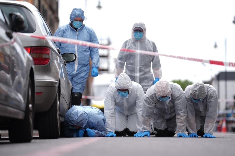 a group of people in protective suits are kneeling on the ground