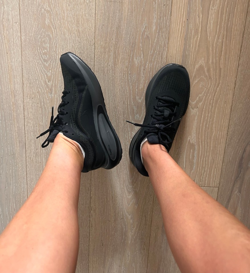 a person wearing a pair of black nike shoes