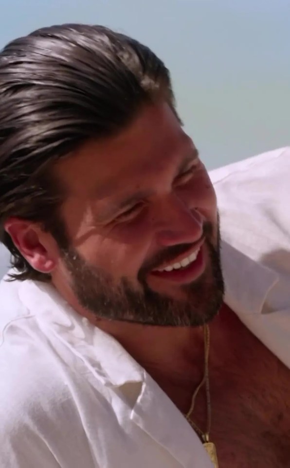 a man with a beard and a white shirt is smiling
