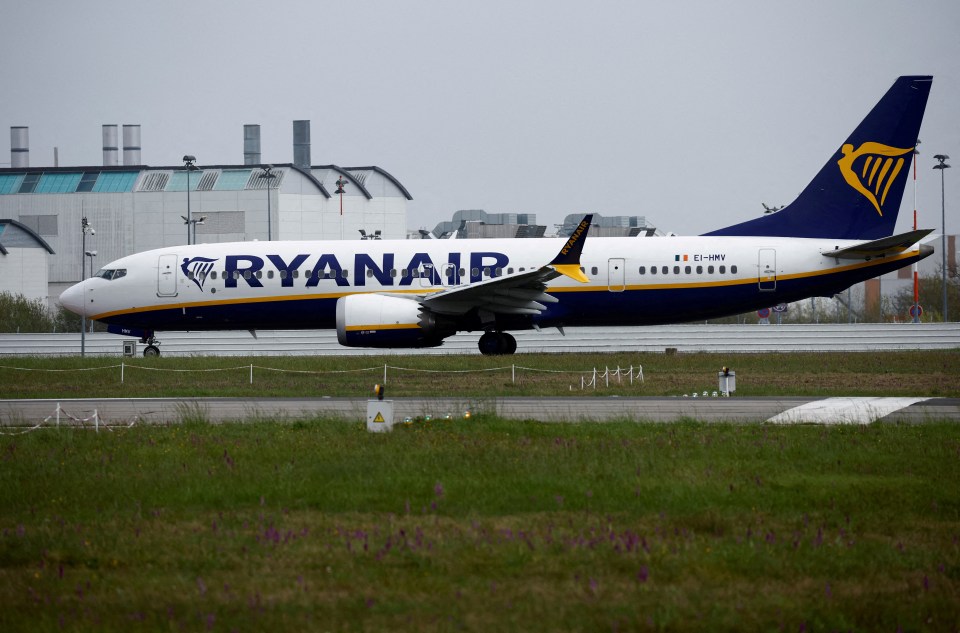a ryanair plane sits on a runway in front of a building