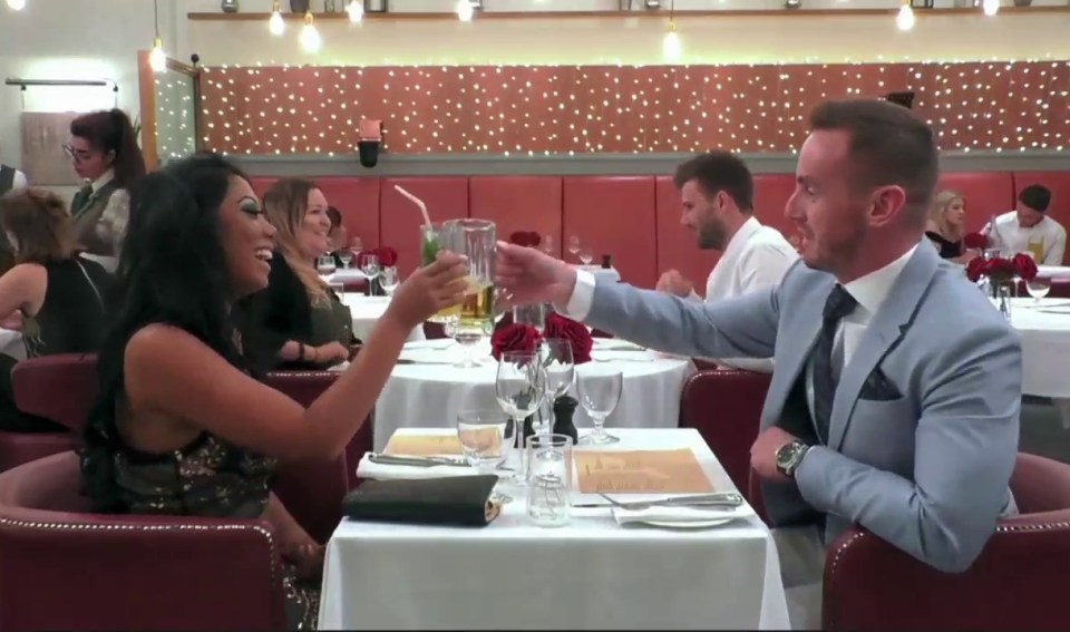 a man and a woman are toasting in a restaurant