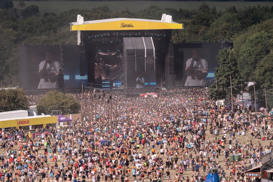 a large crowd of people are gathered at a music festival