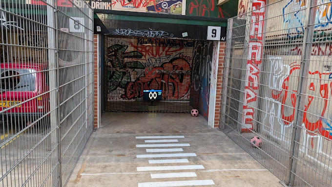 a fenced in area with graffiti and a sign that says soft drink