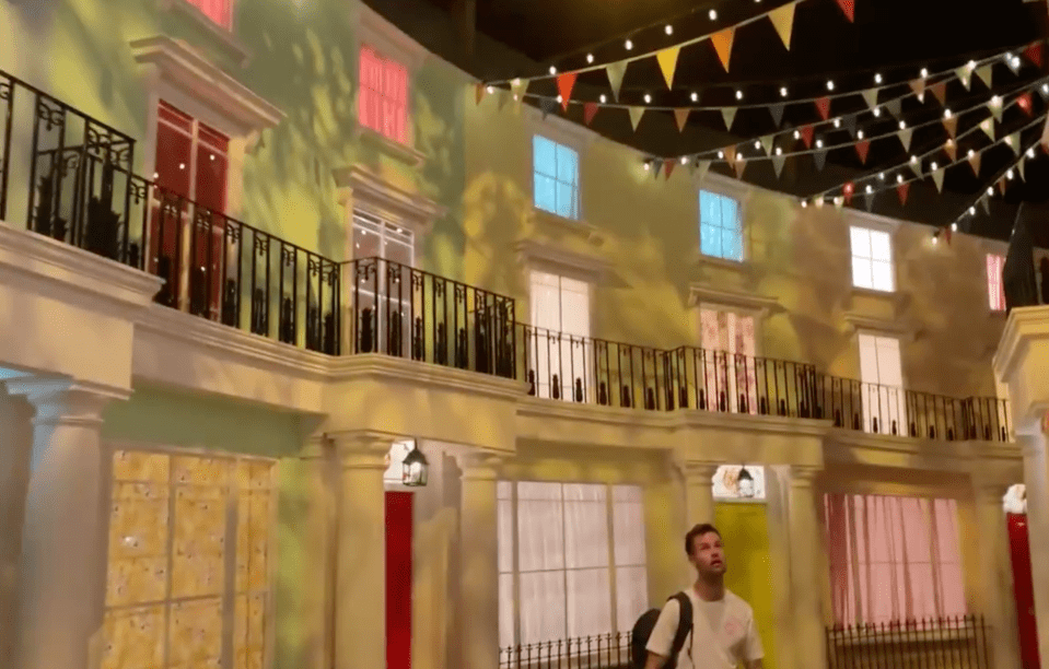 a man standing in front of a building with a balcony