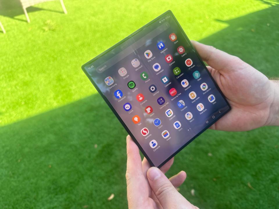 a person is holding a phone with a bunch of apps on it