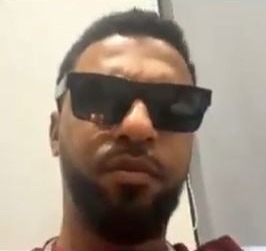 a man with a beard and sunglasses is making a funny face .