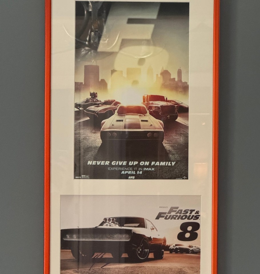 a poster for fast and furious 8 hangs on a wall