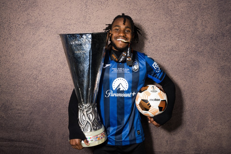a man in a paramount shirt holds a trophy and a soccer ball