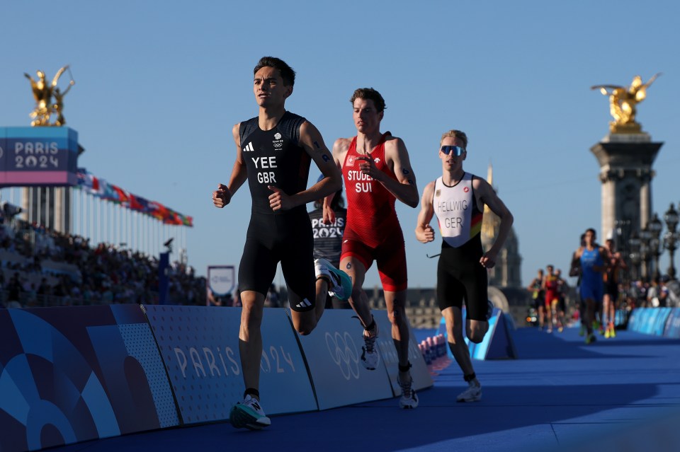 a group of runners are running in front of a sign that says paris 2024